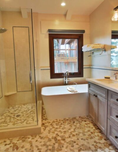 Modern bathroom with a glass shower enclosure, freestanding tub, and double vanity.