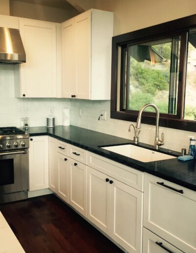 Modern kitchen with stainless steel appliances, white cabinetry, and a subway tile backsplash.