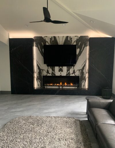 Modern living room with a marble fireplace and mounted flat-screen tv.